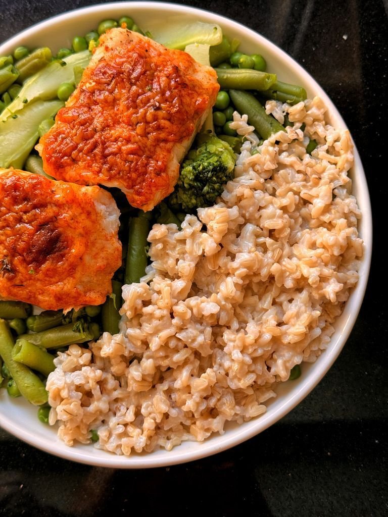 Rice with cheese sauce, green vegetables and fish